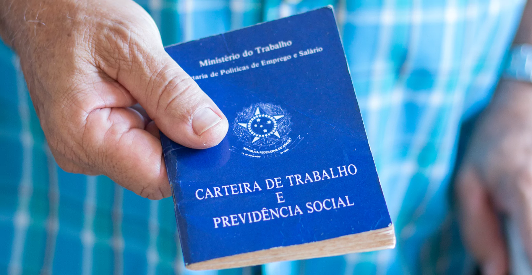 pessoa segurando uma carteira de trabalho representando as regras sobre marcação de ponto