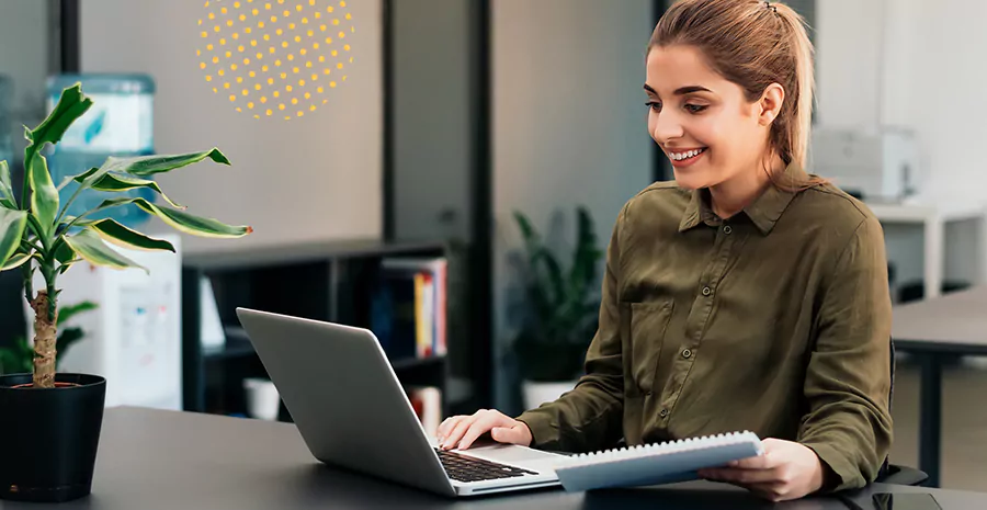 imagem de uma mulher sentada na frente de um computador sorrindo
