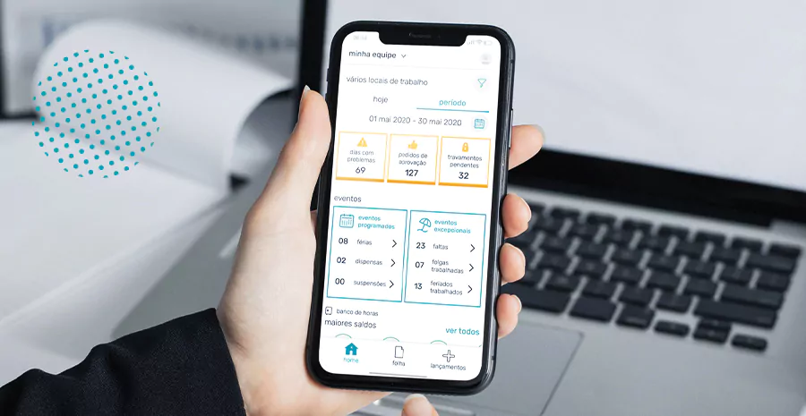 notebook ao fundo e pessoa segurando celular em primeiro plano em que a tela reproduz o app gestão do sistema pontotel onde aponta faltas atrasos e outras coisas da equipe do gestor
