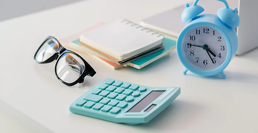 mesa com óculos, relógio e caderno