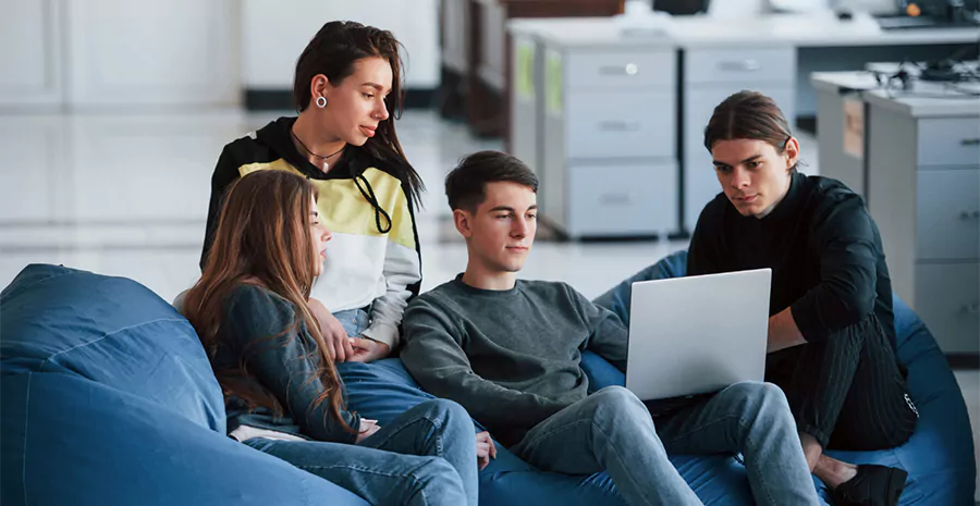 grupo de jovens sentados mexendo no notebook