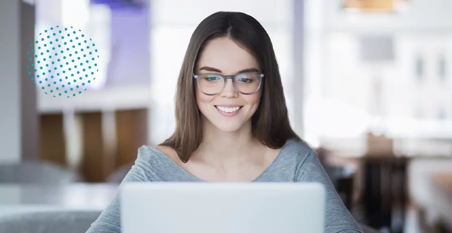 imagem de uma mulher sorrindo sentada na frente de um computador