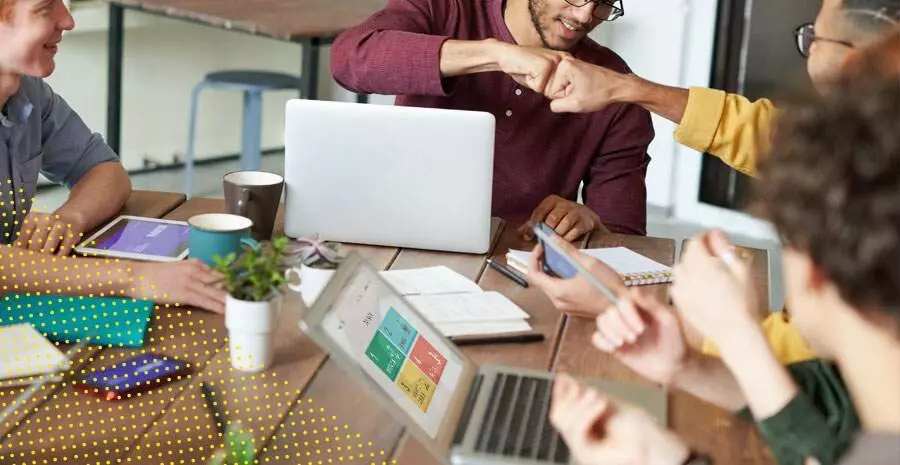 imagem de pessoas sentadas em uma mesa de trabalho 