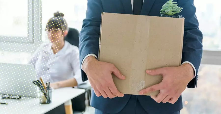 imagem de um homem segurando caixas com objetos de escritório