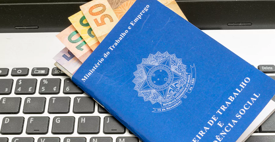 imagem de uma carteira de trabalho com dinheiro dentro