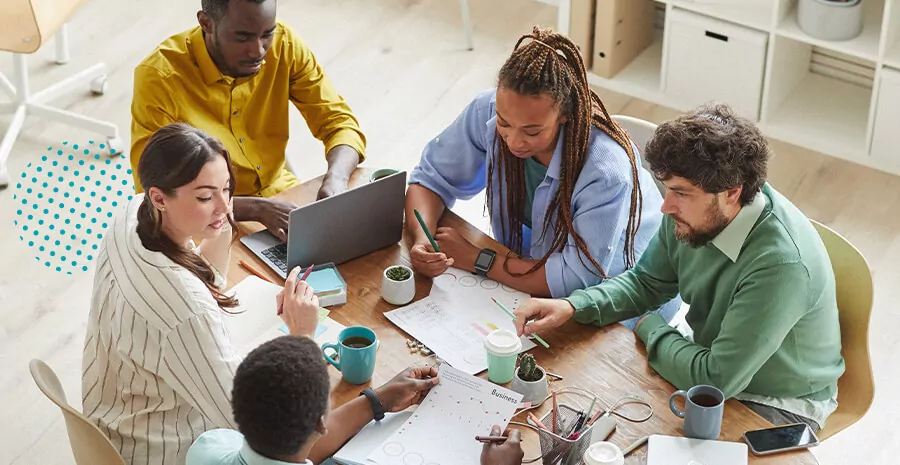 imagem de pessoas reunidas em uma mesa de trabalho