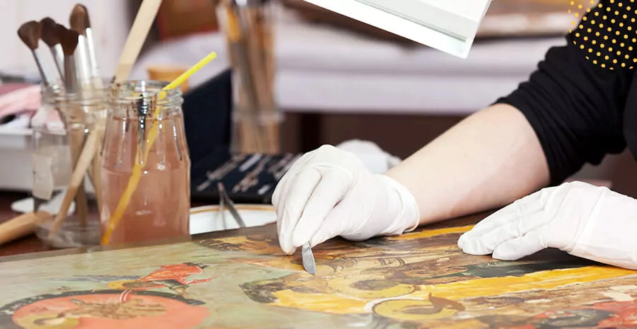 imagem uma mão segurando uma pequena faca para descascar as pinturas