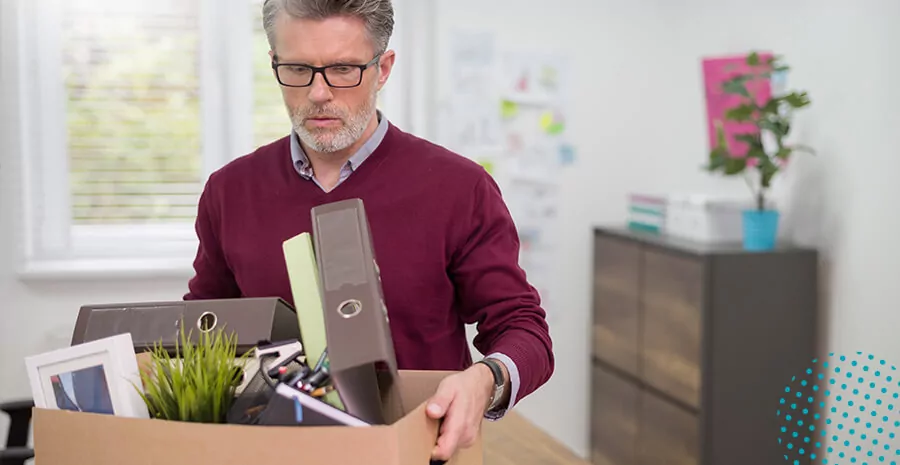 imagem de um homem segurando uma caixa com diversos objetos de trabalho na demissão sem justa causa