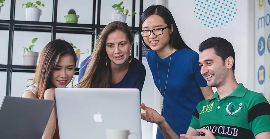 quatro pessoas olhando para um computador e conversando