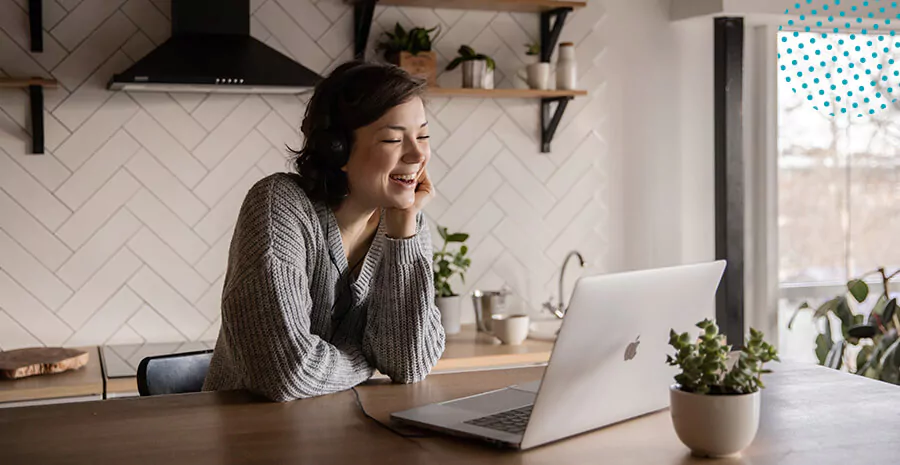 imagem de uma mulher dando risada em frente a tela do computador