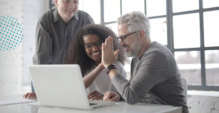 imagem de um grupo junto à frente de um computador. Todos olham para a tela