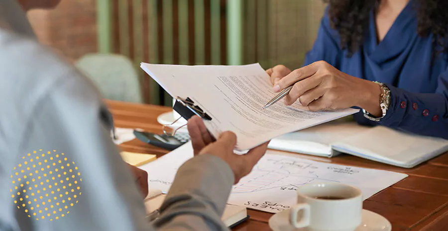 imagem de uma pessoa entregando para a outra os papéis referente à rescisão de contrato intermitente