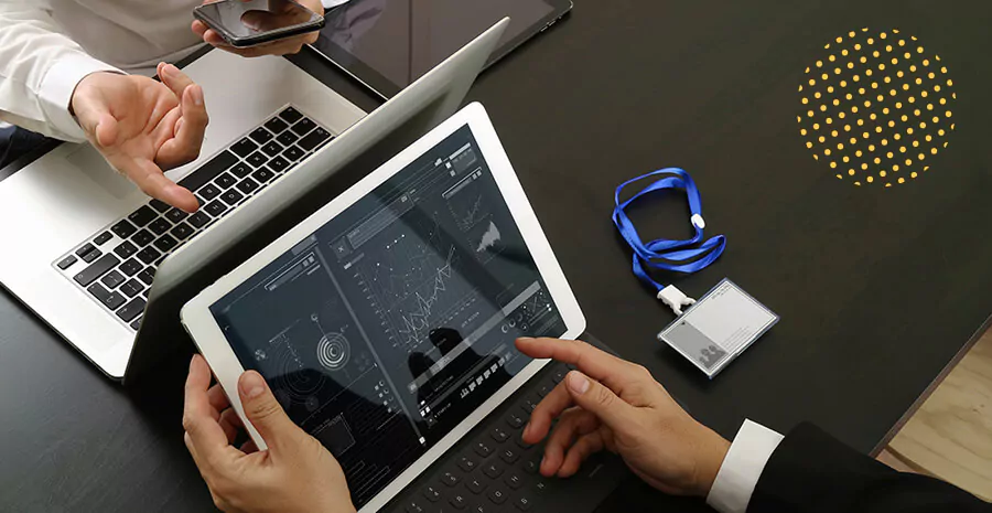 imagem com foco em um computador e um tablet com gráficos na tela