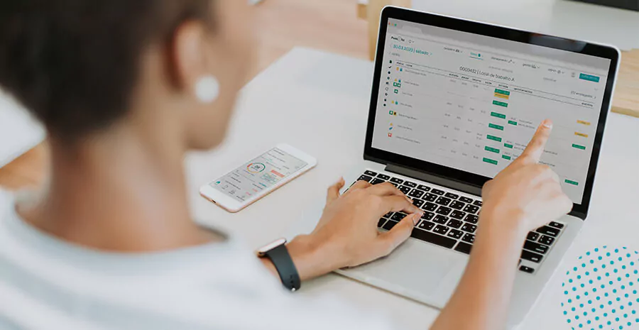 imagem de uma mulher apontando pra tela do computador mostrando o sistema da pontotel que pode auxiliar em evitar ações trabalhistas