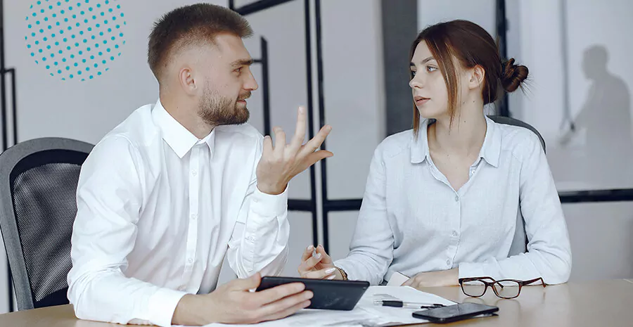 imagem de um homem e uma mulher conversando em um ambiente corporativo