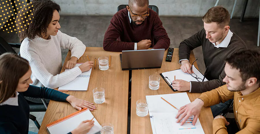 imagem de pessoas reunidas em uma mesa de trabalho