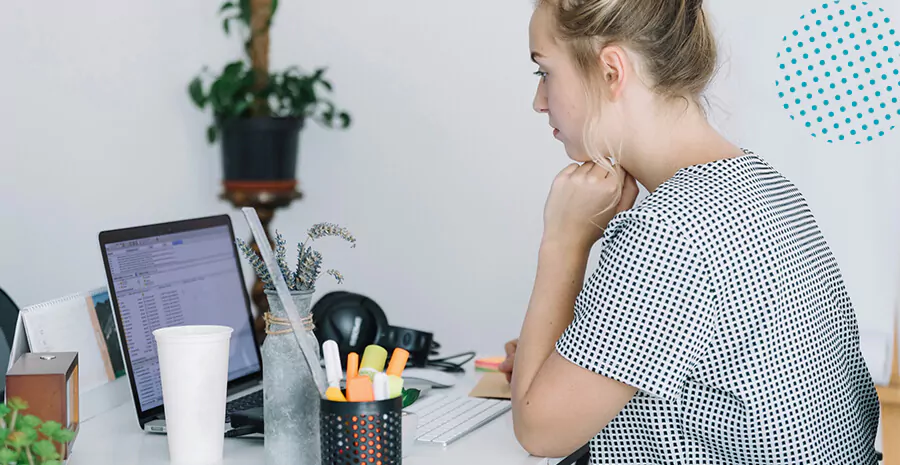 imagem de uma mulher mexendo no computador com outros objetos de escritório ao lado