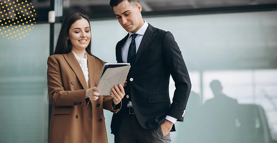 imagem de um homem e uma mulher usando roupas sociais e segurando um caderno