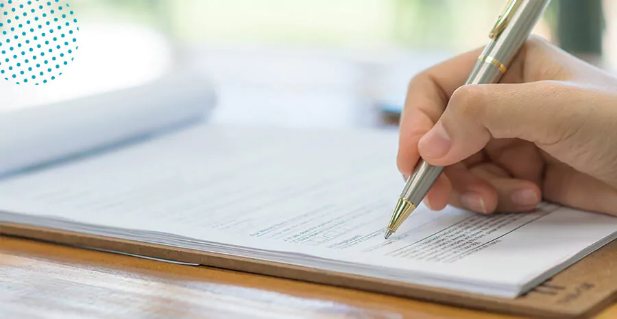 imagem de uma mão segurando uma caneta preenchendo o documento de perfil profissiográfico previdenciário no papel