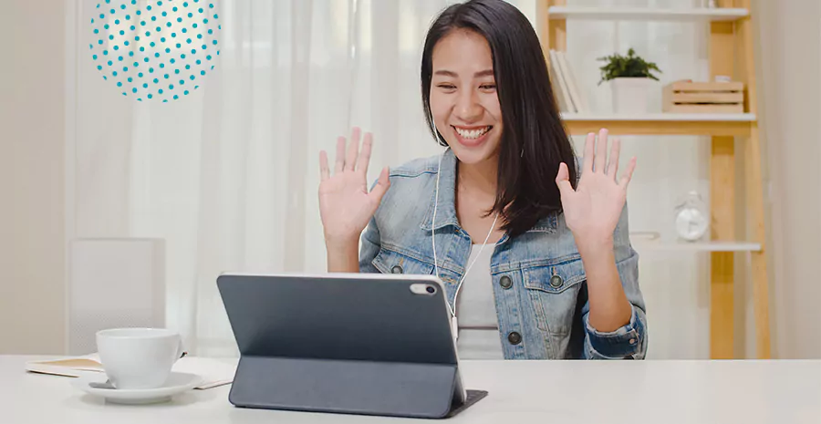 imagem de uma mulher sorrindo levantando as mãos de frente para um tablet