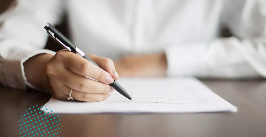 imagem de uma pessoa escrevendo em um papel com uma caneta