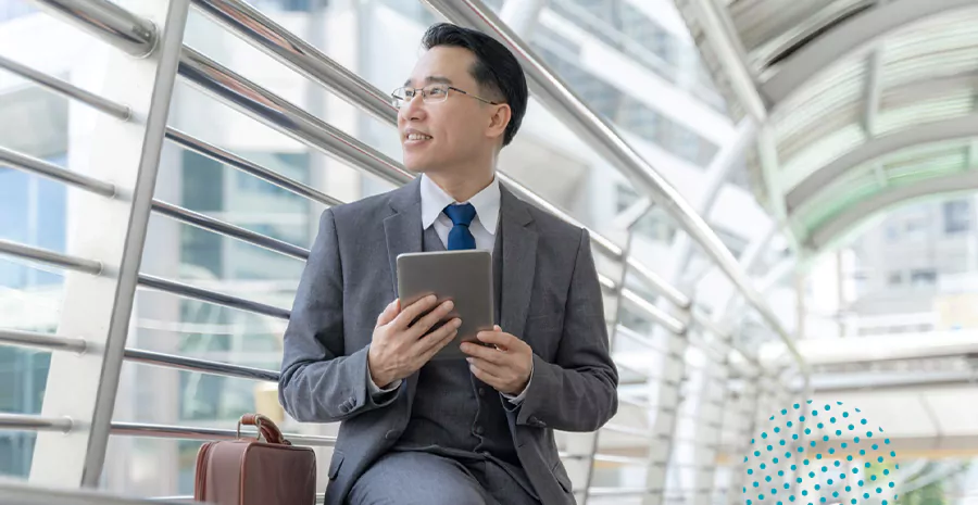 imagem de um homem sentado segurando um tablet