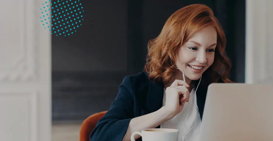 imagem de uma mulher sorrindo olhando para o computador e segurando um lápis