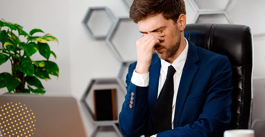 imagem de um homem preocupado com a mão no rosto sentado na frente de um computador