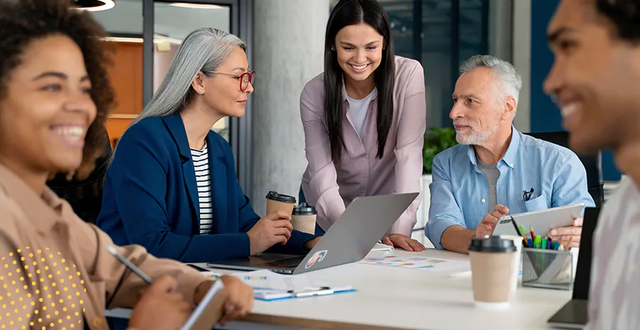 imagem de um grupo de pessoas sorrindo sentado ao redor de uma mesa