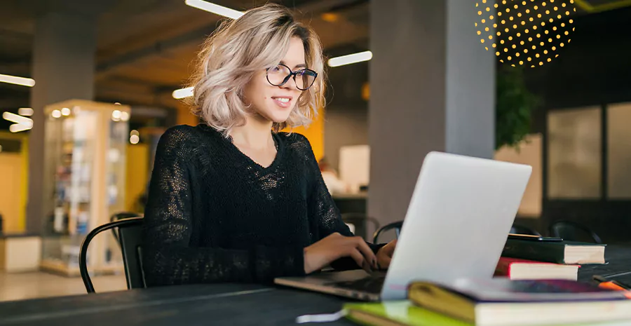 imagem de uma mulher sorrindo sentada na frente de um computador