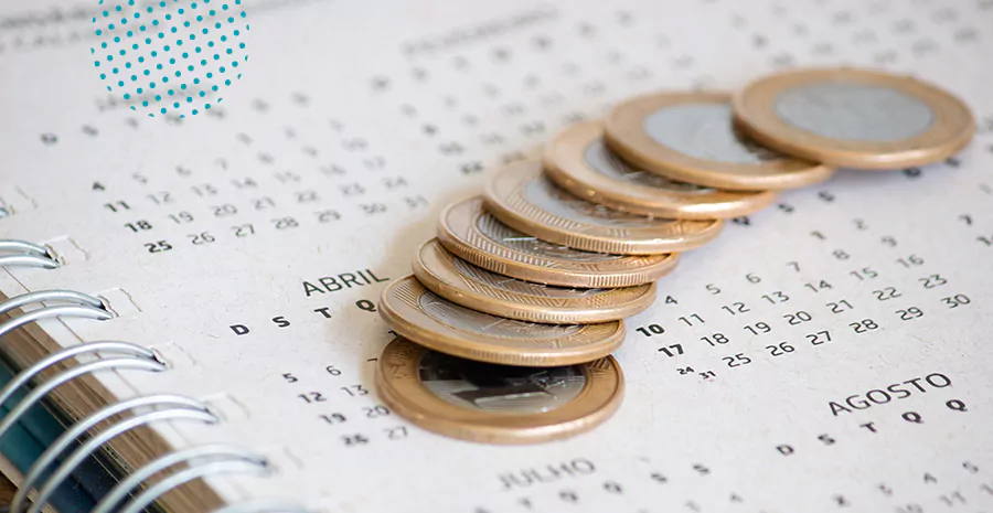 imagem de moedas de um real em cima de um calendário