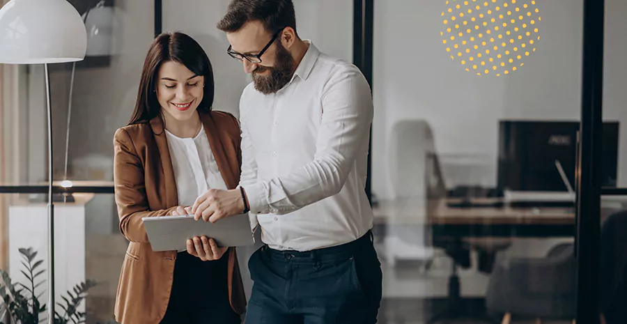 imagem de um homem e uma mulher em pé segurando um tablet