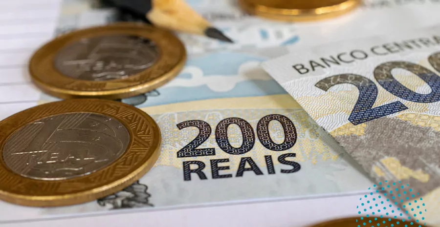 imagem de notas de duzentos reais ao lado de moedas de um real