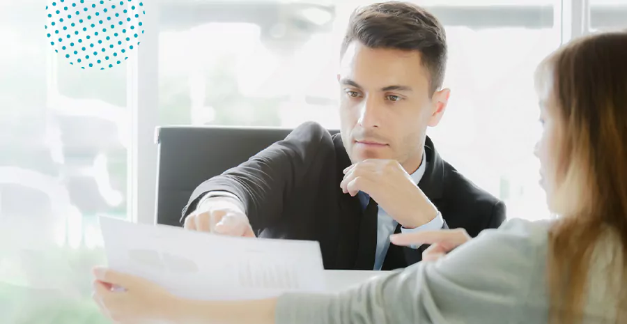 imagem de um homem e uma mulher segurando um papel e analisando