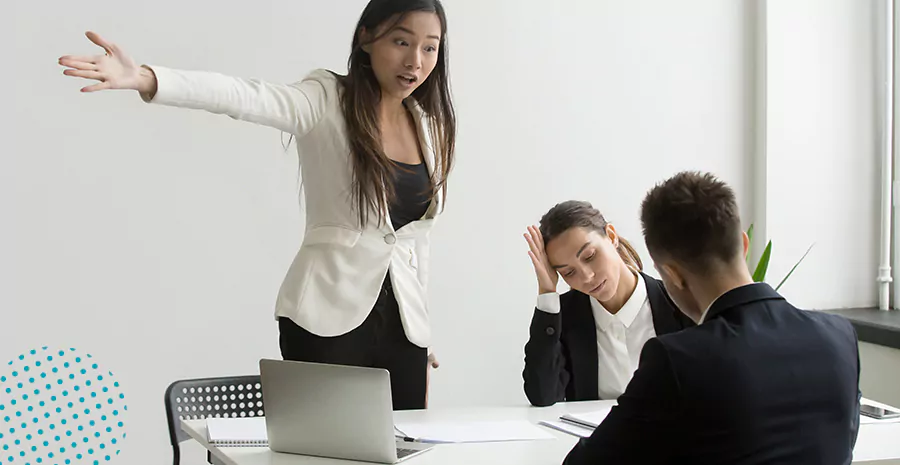 imagem de uma mulher em pé discutindo com um homem e uma mulher sentados em uma mesa