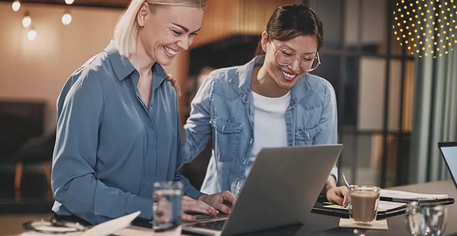 imagem de duas mulheres sorrindo mexendo em um computador