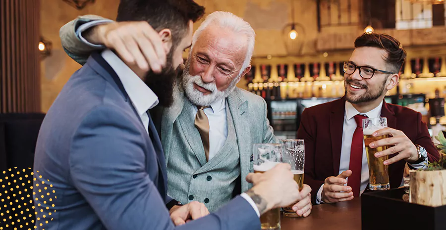 imagem de três homens em um bar celebrando e bebendo