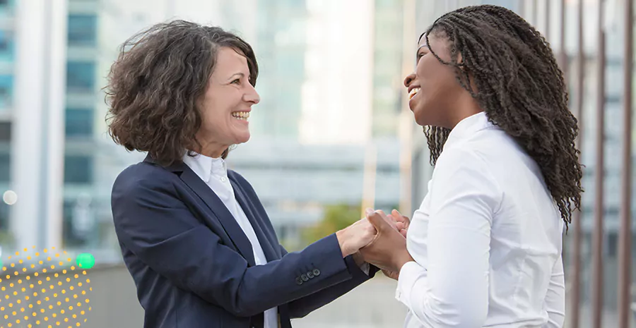 imagem de duas mulheres sorrindo e se cumprimentando