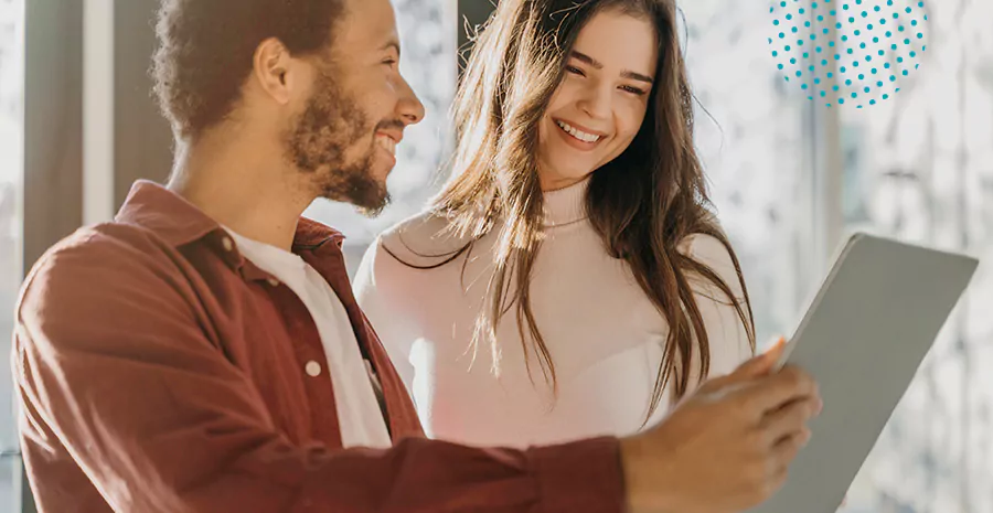 imagem de um homem e uma mulher sorrindo segurando um tablet