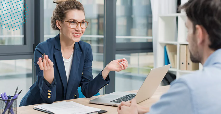 imagem de uma mulher e um homem conversando sentados em uma mesa