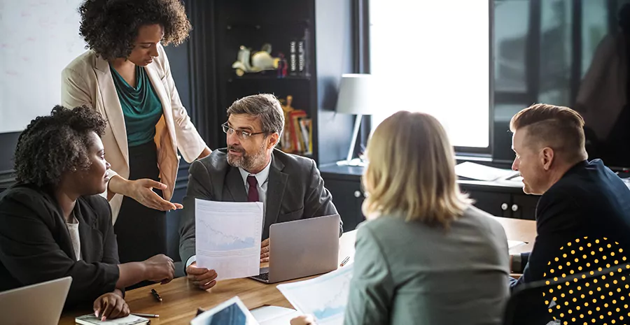 imagem de um grupo de pessoas sentado ao redor de uma mesa em um escritório