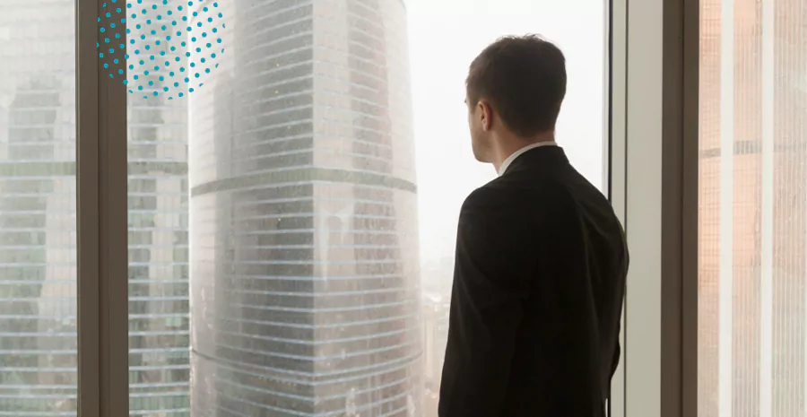 imagem de um homem em pé olhando para um prédio de uma janela