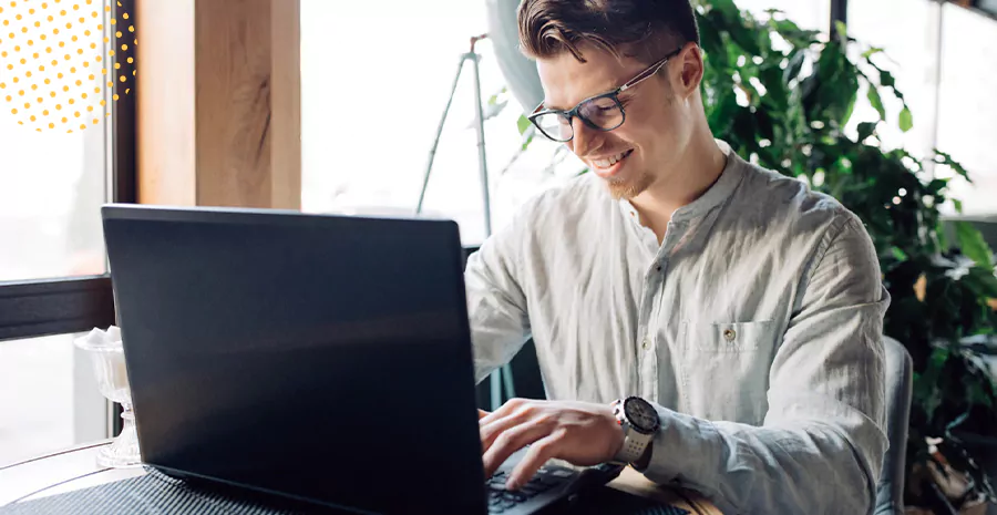 imagem de um homem sorrindo sentado na frente de um computador