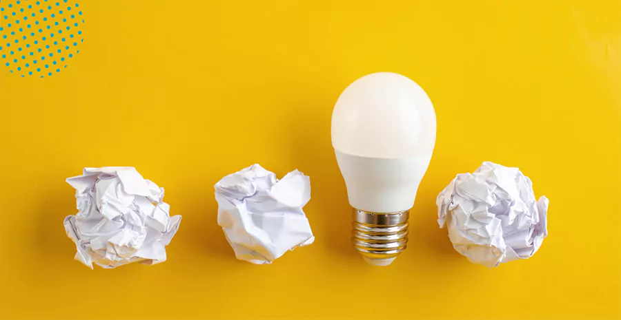 imagem de uma lâmpada ao lado de três bolas de papel amassadas