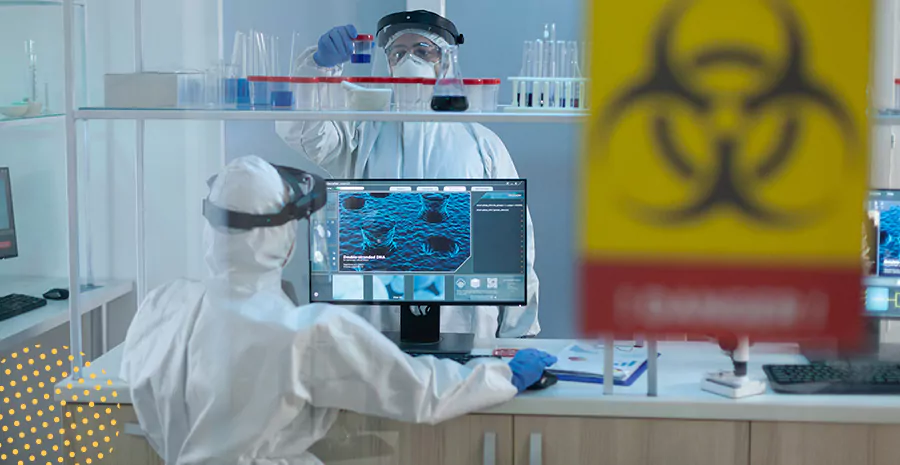 imagem de duas pessoas em um laboratório usando roupas de proteção