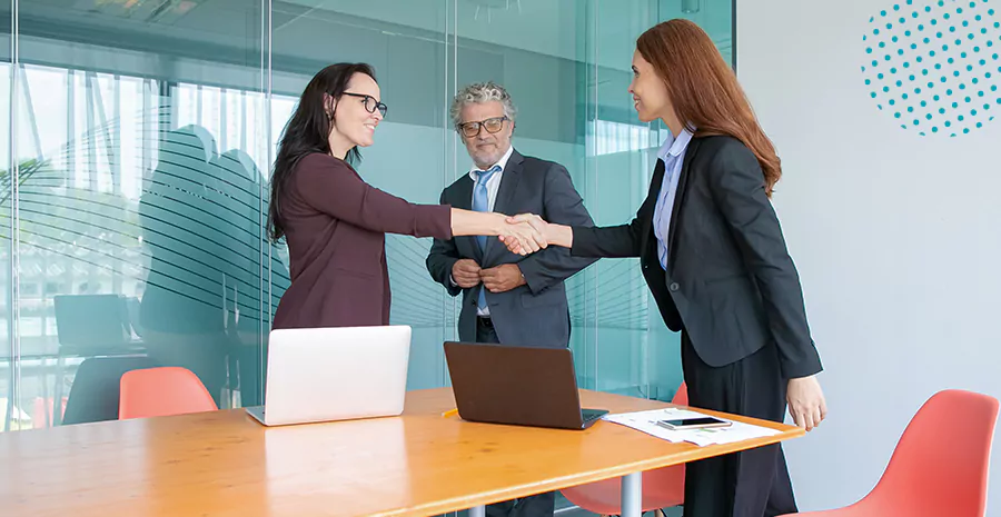 imagem de duas mulheres se cumprimentando com um homem ao lado