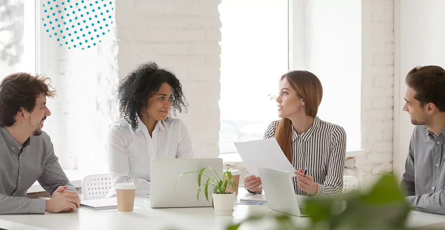 imagem de duas mulheres e dois homens sentados em uma mesa conversando