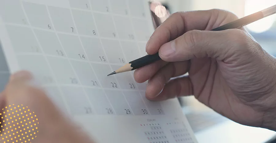 imagem de uma pessoa escrevendo em um calendário