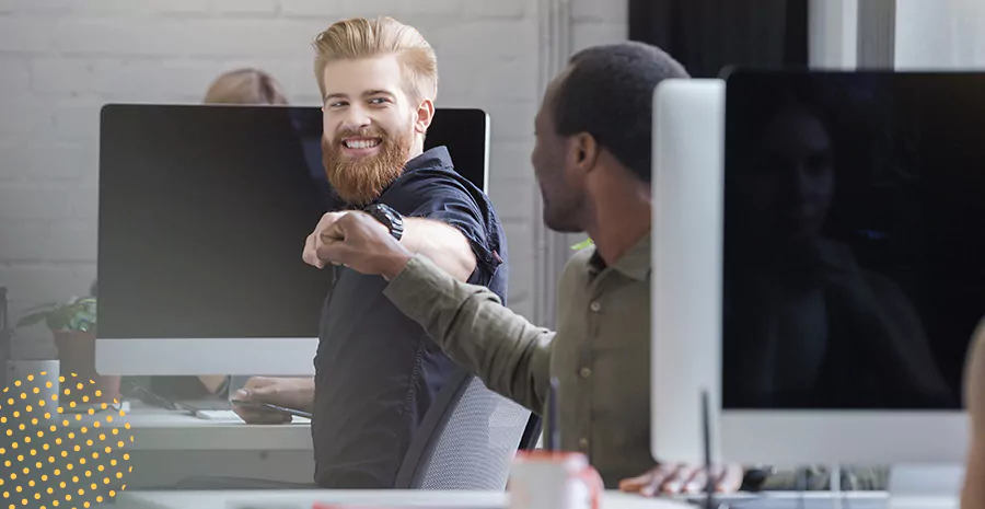 imagem de dois homens sentados de frente para o outro sorrindo e se cumprimentando