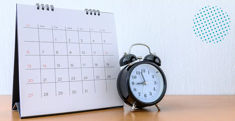 imagem de um calendário e um relógio em cima de uma mesa